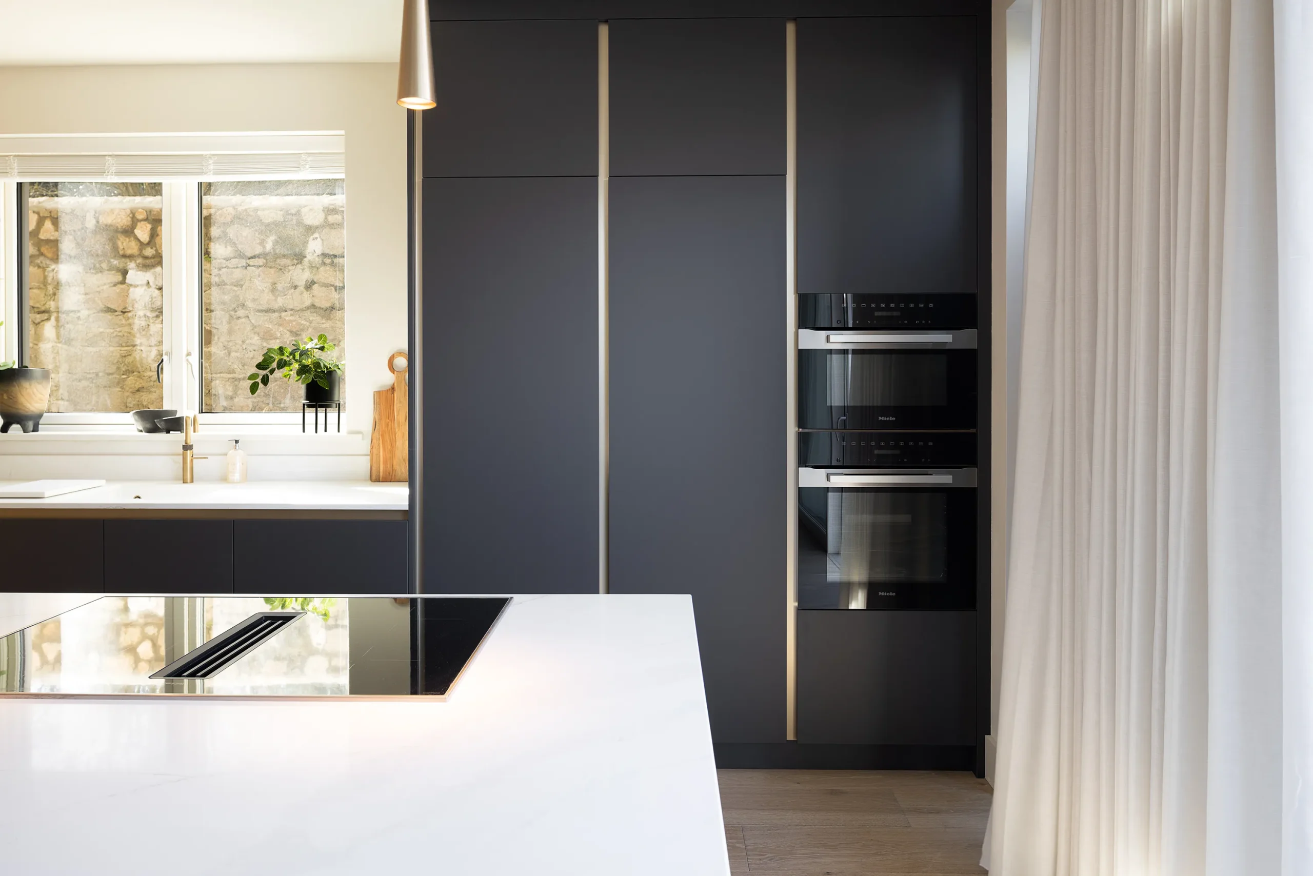 Interior design and joinery detail from the Blackrock home by Gavelle, in a palette of matte charcoal, warm oak, brushed brass and natural stone
