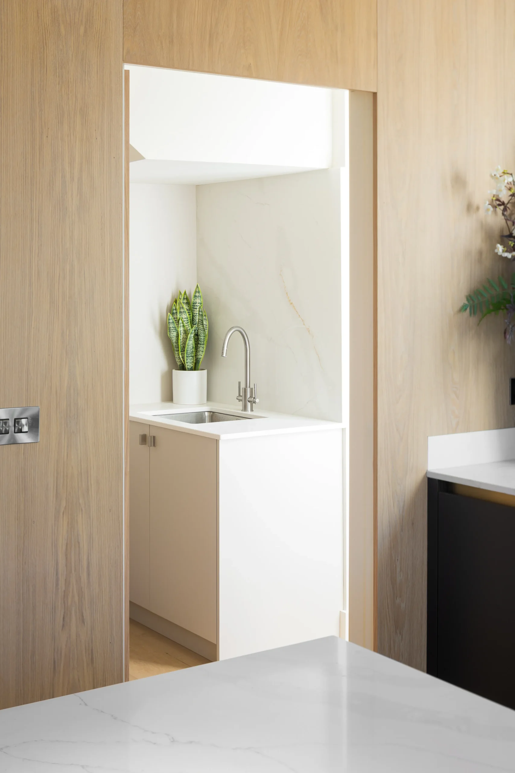 Interior design and joinery detail from the Blackrock home by Gavelle, in a palette of matte charcoal, warm oak, brushed brass and natural stone
